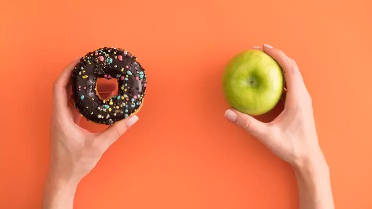 Image of a doughnut in the left hand and apple in the right hand 'comparing donuts and apples'
